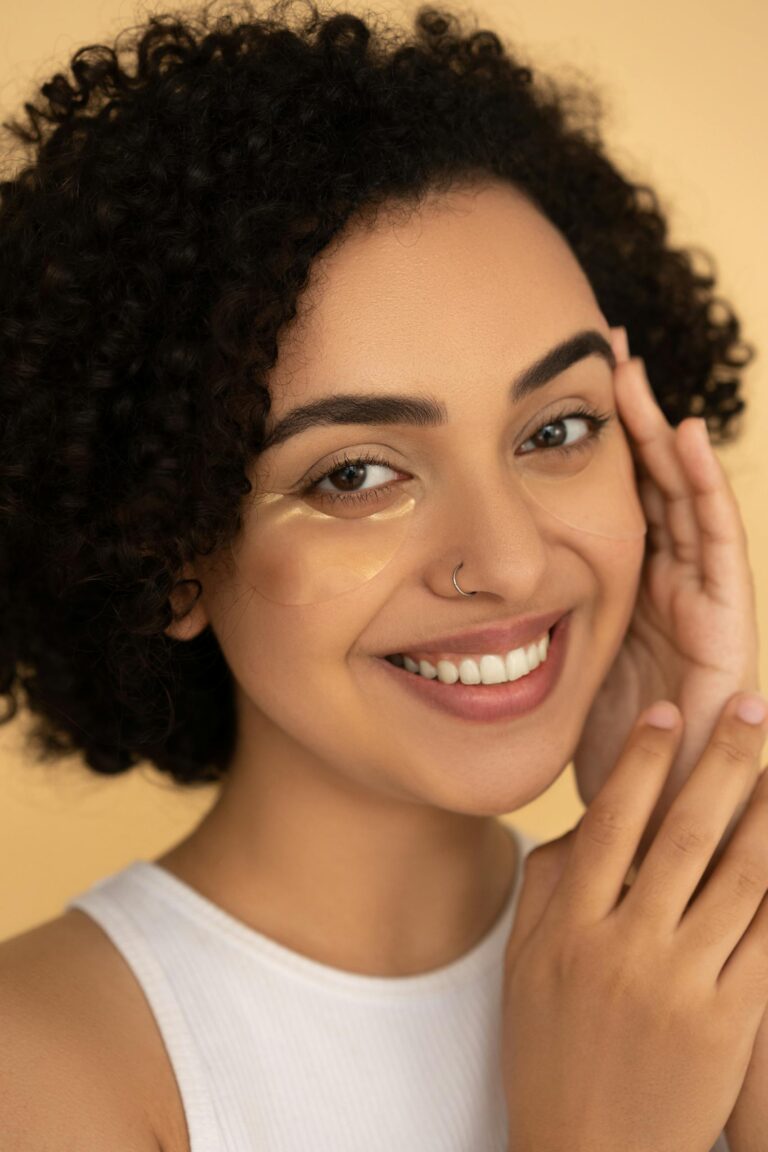 Cheerful woman with under eye patches, showcasing skincare routine and healthy lifestyle.